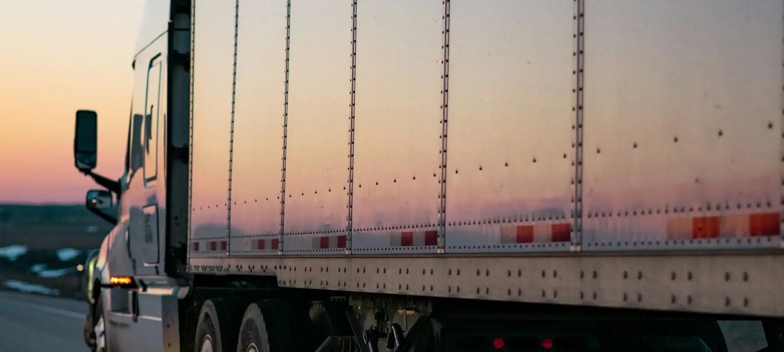 Sattelzug mit Kofferauflieger in der Abenddämmerung auf der Autobahn