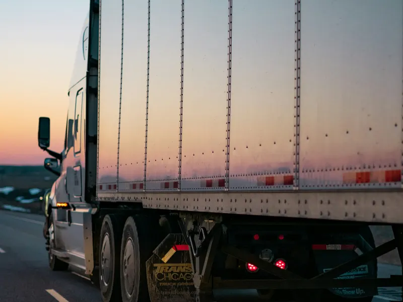 Sattelzug mit Kofferauflieger in der Abenddämmerung auf der Autobahn